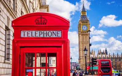 traditionelle rote britische Telefonzelle mit Big Ben und Doppeldeckerbus im Hintergrund in London