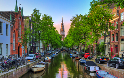 Groenburgwal-Kanal in Amsterdam mit der Soutern-Kirche (Zuiderkerk) bei Sonnenuntergang im Sommer